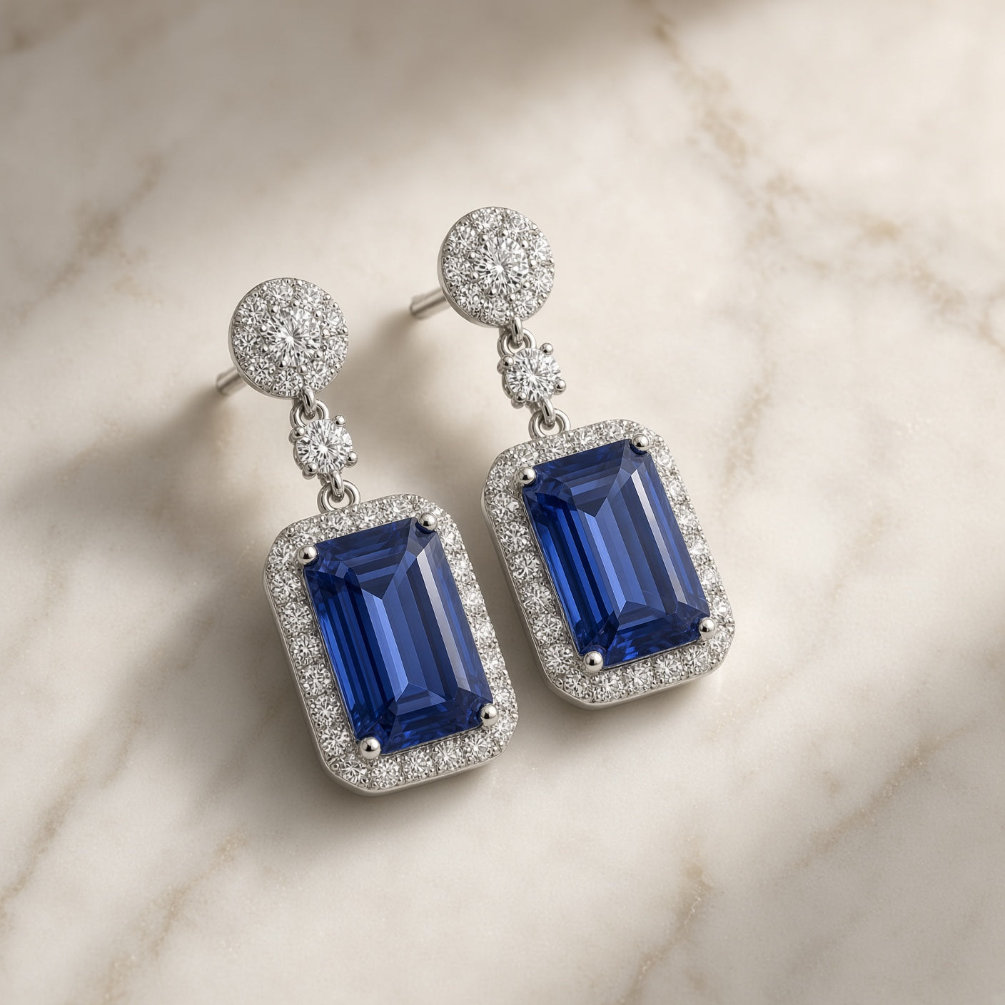 Tanzanite and diamond halo earrings at an angle, showing the diamond cluster tops and 18K white gold settings
