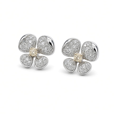 Diamond flower stud earrings with yellow diamond centers, angled view