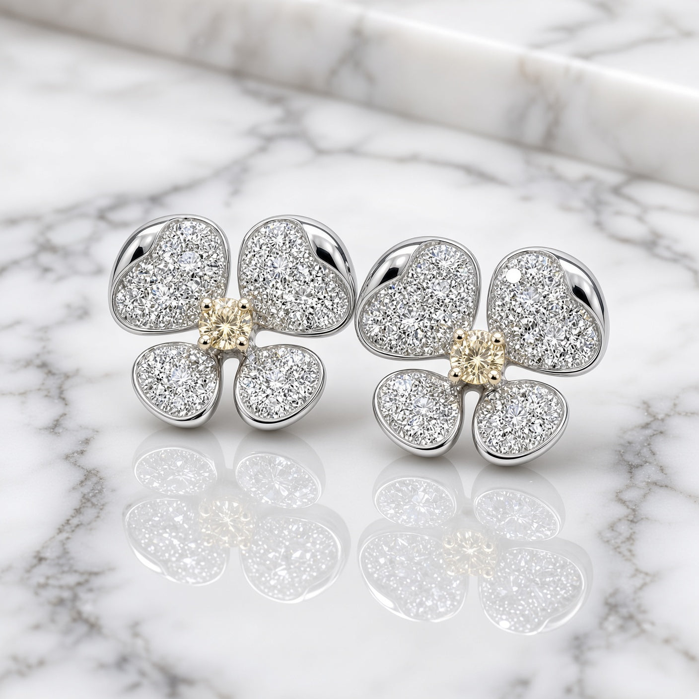Yellow and white diamond flower earrings on white marble