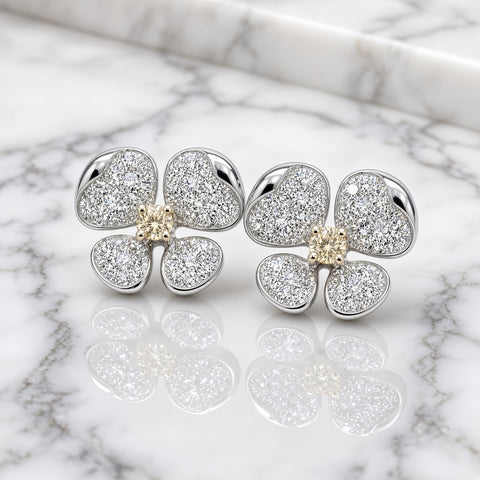 Yellow and white diamond flower earrings on white marble