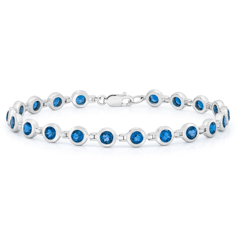 A bracelet featuring round blue gemstones set in a white gold metal bracelet with a buckle clasp.