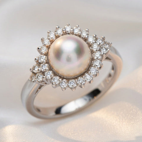 Close-up of ISAAC WESTMAN® diamond and pearl ring showcasing intricate design and sparkling gemstones on a white background.