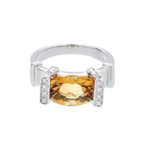 Gold ring with a central diamond and citrine gemstone, crafted by Isaac Westman, showcasing elegant jewelry design.