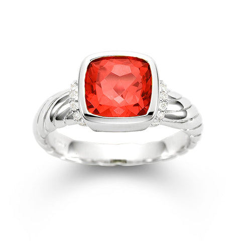 Garnet and diamond ring by ISAAC WESTMAN featuring a central red garnet gemstone with sparkling diamonds on a silver band.